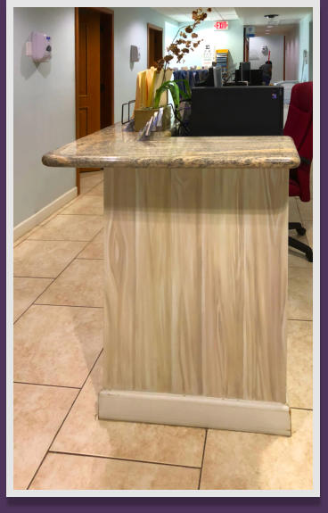 A faux wood desk are at a doctor's office.
